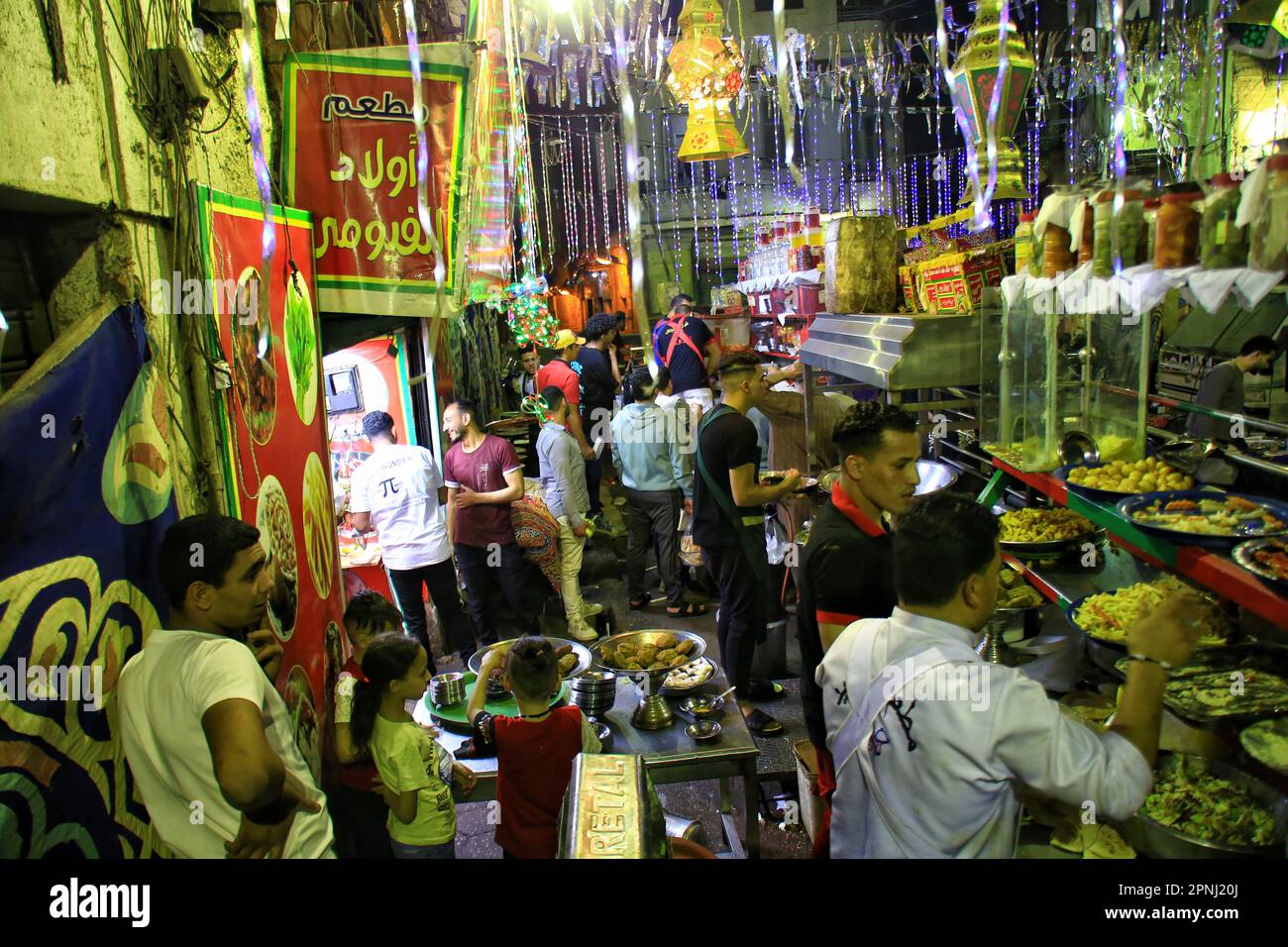 La gente si siede in un ristorante di strada per mangiare il tradizionale cibo egiziano ''Suhoor'', un punto di spilla durante il mese santo del Ramadan, il 19 aprile 2023 al Cairo, Egitto. Il digiuno, durante il mese santo del Ramadan, è uno dei cinque pilastri dell'Islam ed è richiesto a tutti i musulmani sani. (Foto di Mahmoud Elkhwas/NurPhoto) Credit: NurPhoto SRL/Alamy Live News Foto Stock