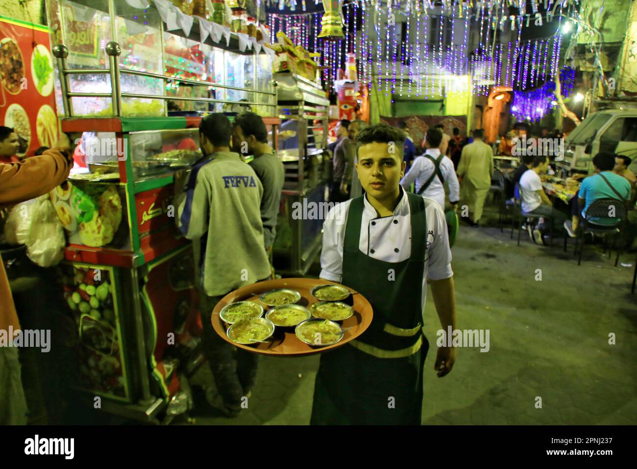 La gente si siede in un ristorante di strada per mangiare il tradizionale cibo egiziano ''Suhoor'', un punto di spilla durante il mese santo del Ramadan, il 19 aprile 2023 al Cairo, Egitto. Il digiuno, durante il mese santo del Ramadan, è uno dei cinque pilastri dell'Islam ed è richiesto a tutti i musulmani sani. (Foto di Mahmoud Elkhwas/NurPhoto) Credit: NurPhoto SRL/Alamy Live News Foto Stock