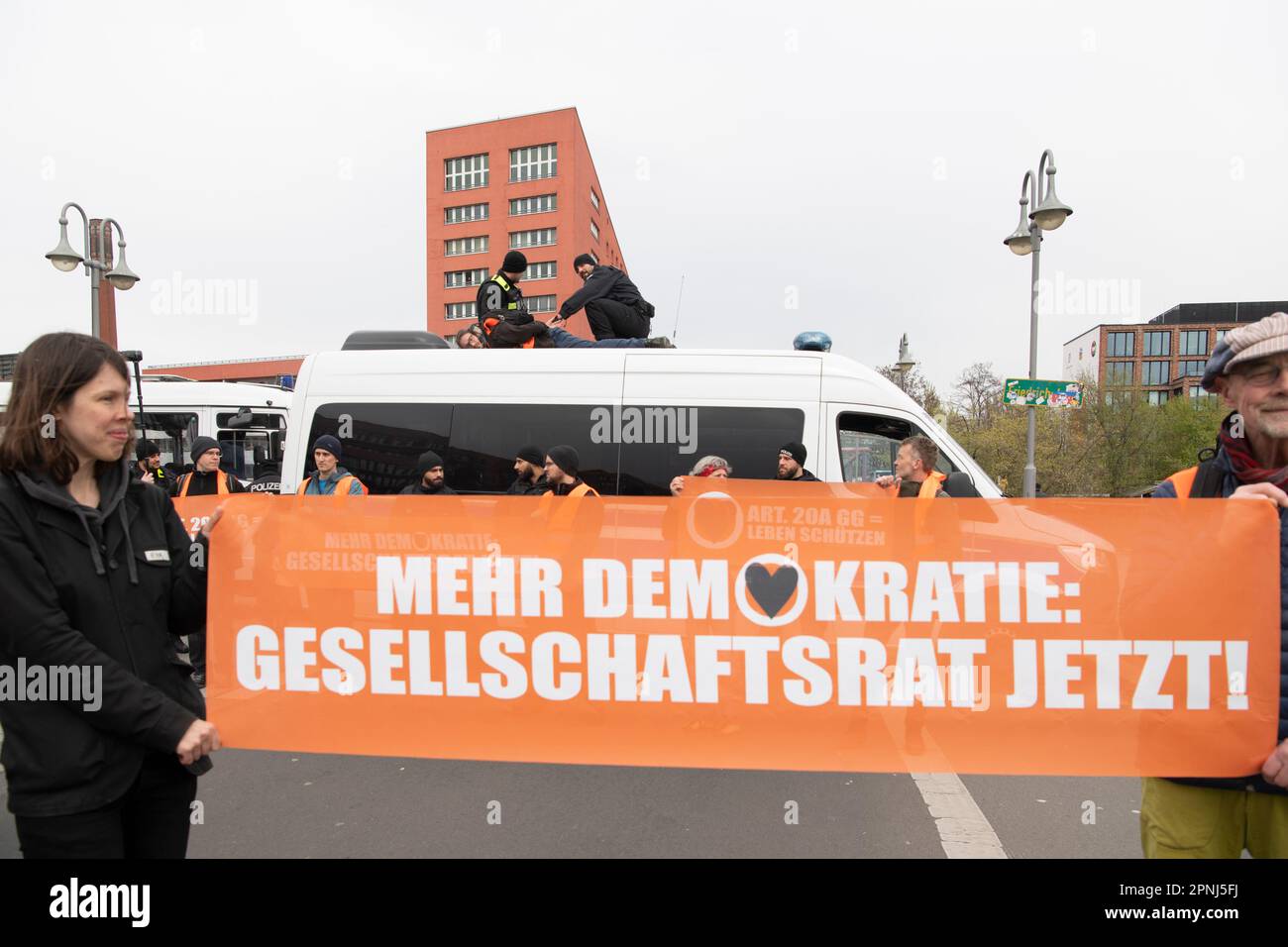 Berlino, Germania. 19th Apr, 2023. Gli attivisti dell'ultima generazione si trovano di fronte a un'auto della polizia. All'inizio dei loro giorni di protesta, numerosi attivisti hanno marciato per la città in vari gruppi, causando notevoli ostacoli al traffico. Credit: Paul Zinken/dpa/Alamy Live News Foto Stock