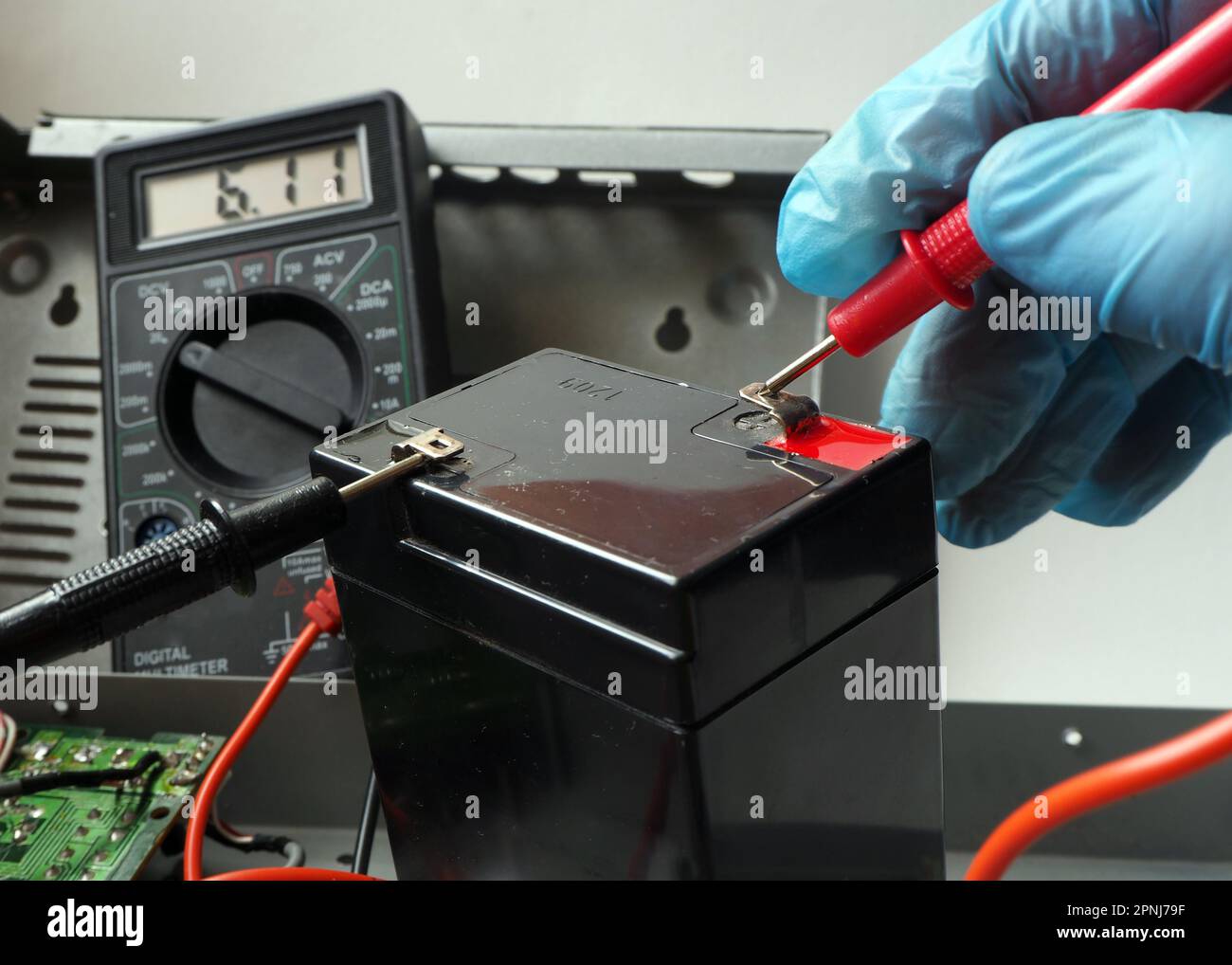 Manutenzione dell'accumulatore per UPS. Test completo della batteria con voltmetro. Foto Stock