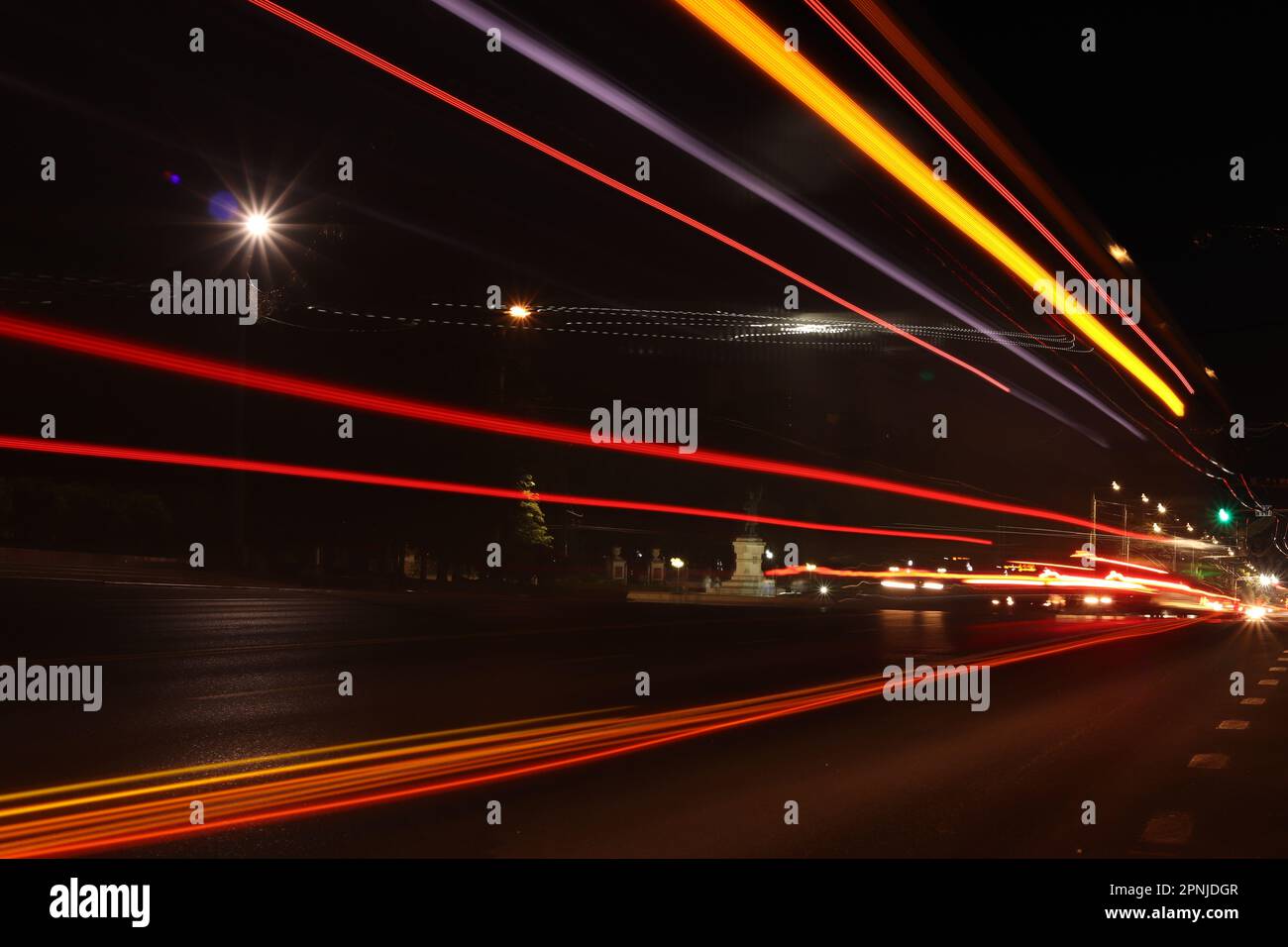 Un lungo scatto di esposizione dei sentieri leggeri di trasporto lungo la strada nella città di notte Foto Stock