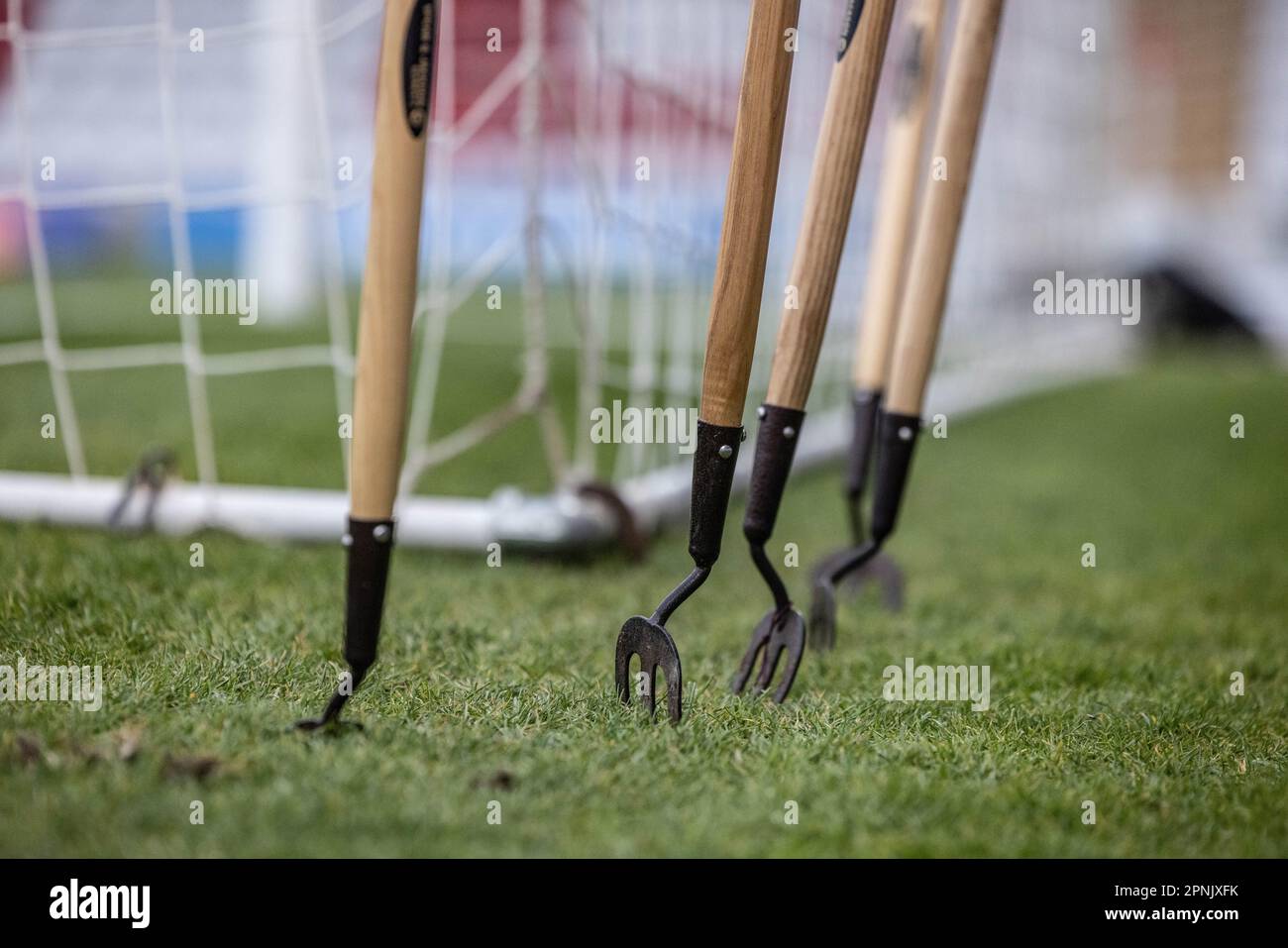 Primo piano delle attrezzature sportive per la manutenzione del campo/campo e per lavori di terra in posizione verticale in erba sul campo da calcio. Foto Stock