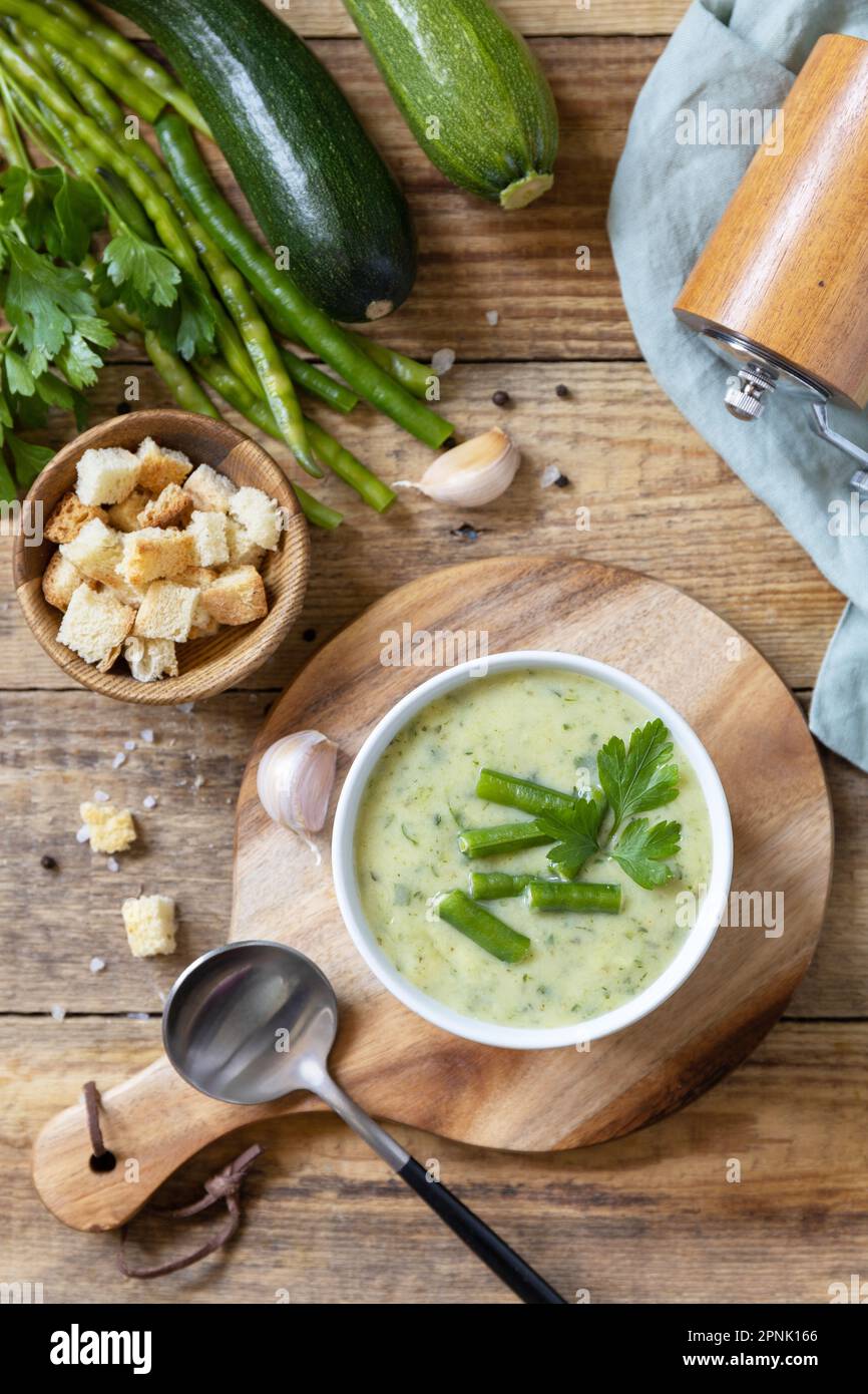 Purea di verdure verdi per zuppa vegana. Ciotola di fagiolo verde e zuccini crema su un tavolo rustico. Dieta sana basso carb. Vista dall'alto. Foto Stock