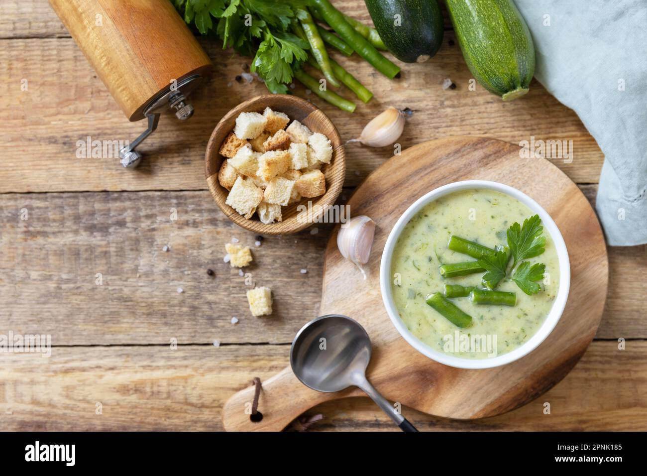 Purea di verdure verdi per zuppa vegana. Ciotola di fagiolo verde e zuccini crema su un tavolo rustico. Dieta sana basso carb. Vista dall'alto. Spazio di copia Foto Stock