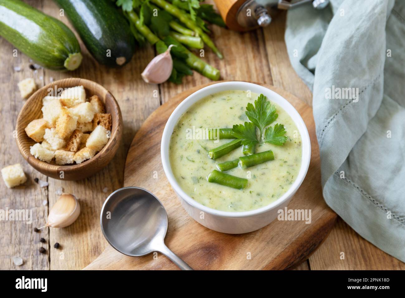 Purea di verdure verdi per zuppa vegana. Dieta sana basso carb. Ciotola di fagiolo verde e zuccini crema su un tavolo rustico. Foto Stock