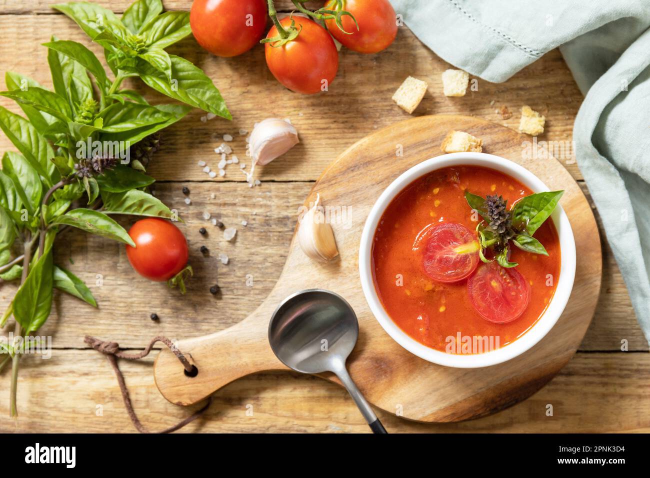 Zuppa vegana pomodori purè. Dieta sana basso carb. Ciotola di zuppa di crema di pomodoro con basilico e crostini su un tavolo rustico. Vista dall'alto. Foto Stock