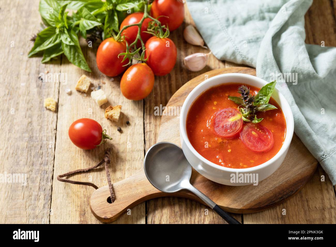 Zuppa vegana pomodori purè. Dieta sana basso carb. Ciotola di zuppa di crema di pomodoro con basilico e crostini su un tavolo rustico. Spazio di copia. Foto Stock
