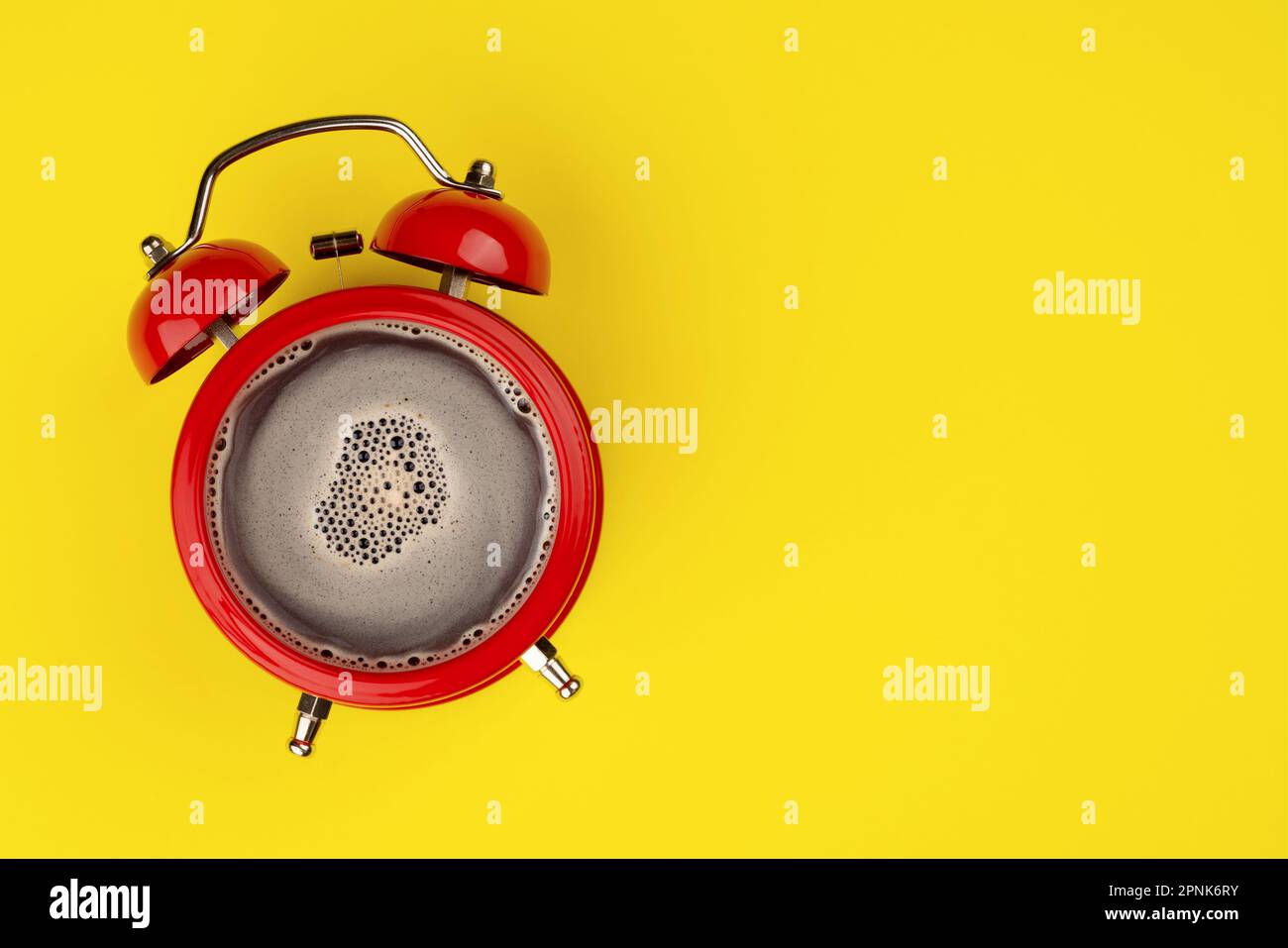 Una sveglia tonificante per il caffè del mattino su sfondo giallo. Caffè nella sveglia con vista dall'alto. Spazio per il testo. Foto Stock