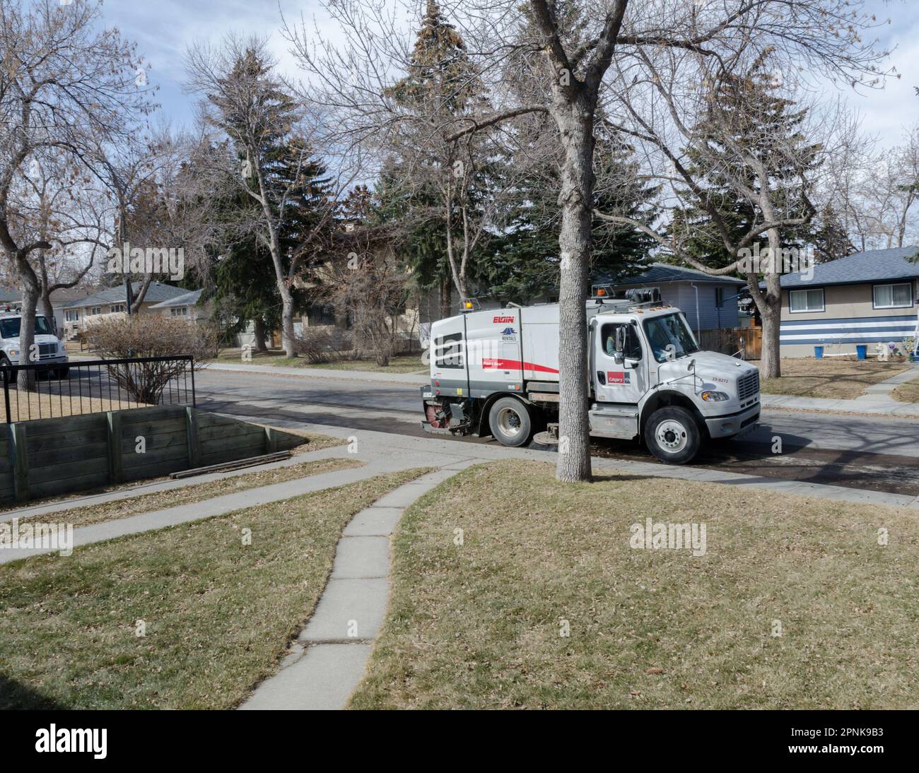 In primavera, le flotte di spazzatrici stradali possono essere viste pulire le strade residenziali a Calgary, Alberta. Prendere nota delle ruote sterzanti doppie. Foto Stock