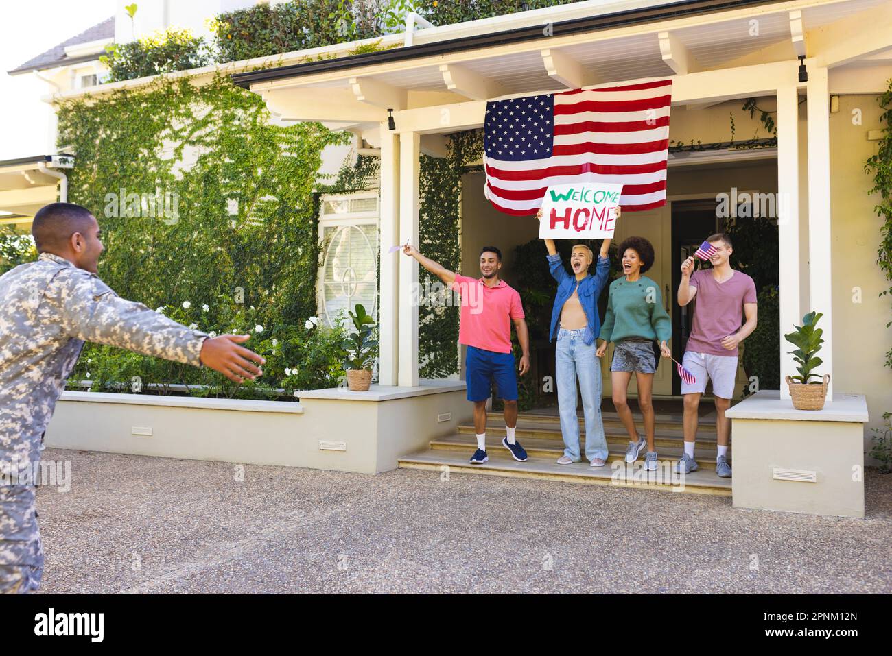 Felice gruppo di amici diversi saluto biracial maschio soldato americano fuori casa Foto Stock