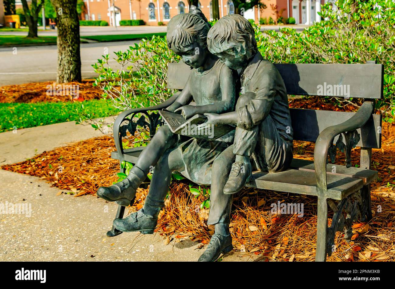 Una scultura in bronzo di due bambini che leggono è raffigurata alla biblioteca pubblica di Bay Minette, il 16 aprile 2023, a Bay Minette, Alabama. Foto Stock