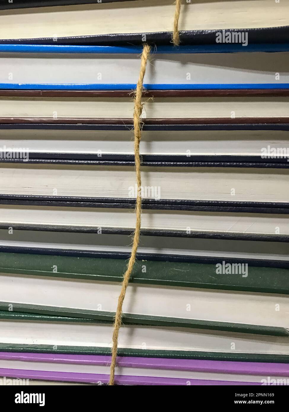Pila di vecchi libri con fondo in corda Foto Stock