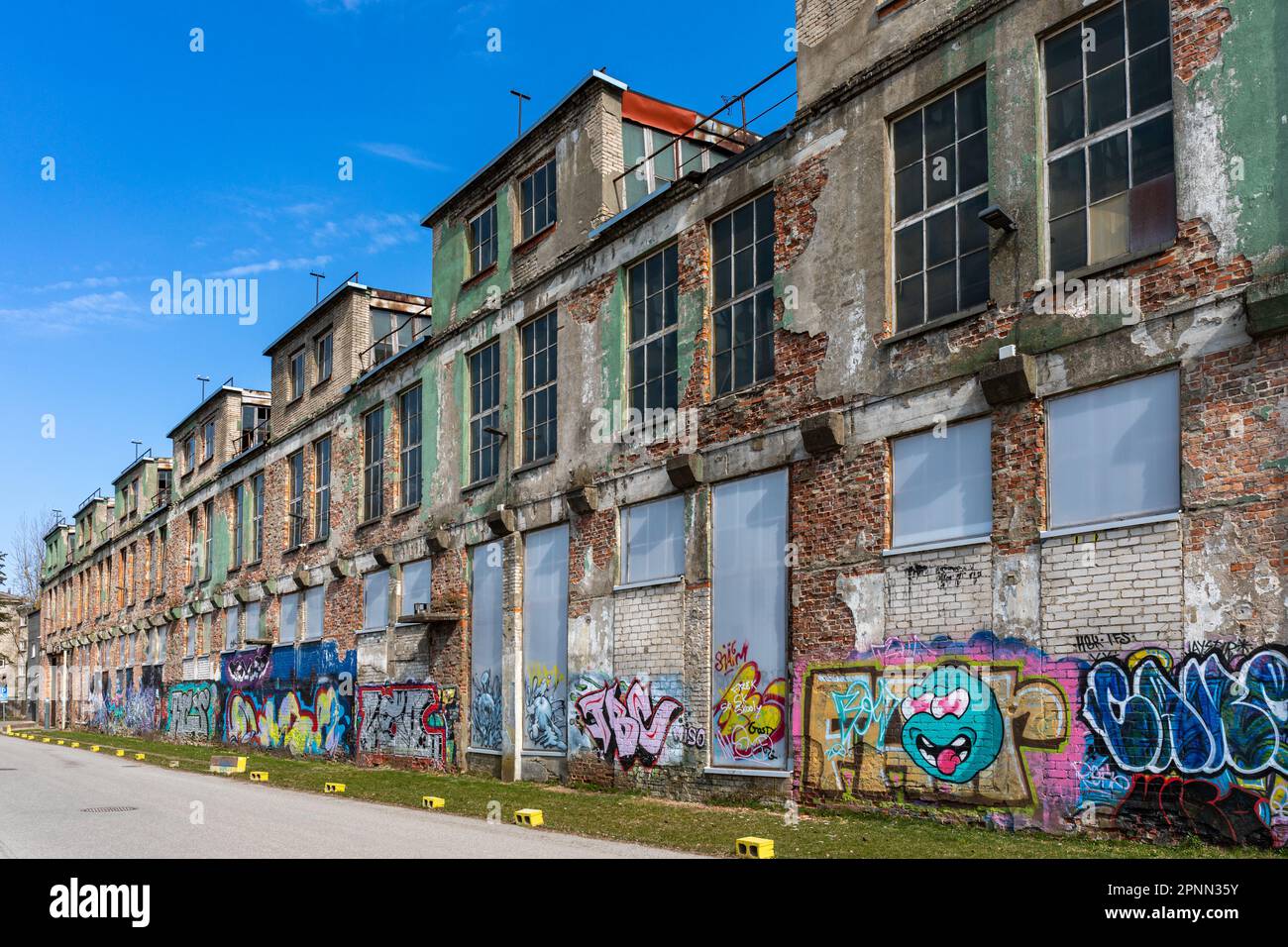 Graffiti coperto vecchio edificio industriale in Telliskivi quartiere di Tallinn, Estonia Foto Stock