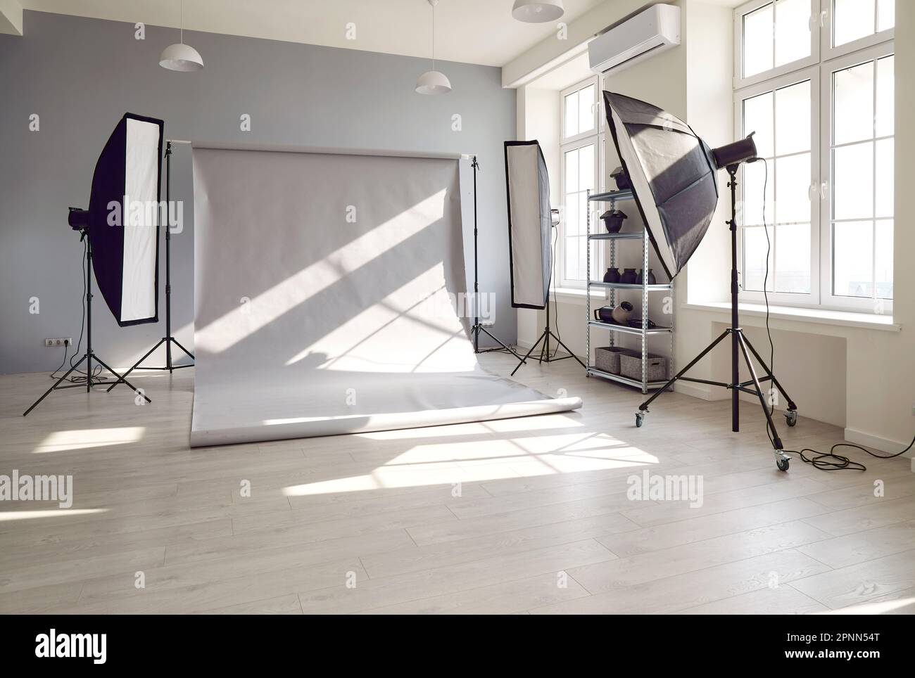 Interni in studio fotografico con sfondo grigio e illuminazione  professionale Foto stock - Alamy