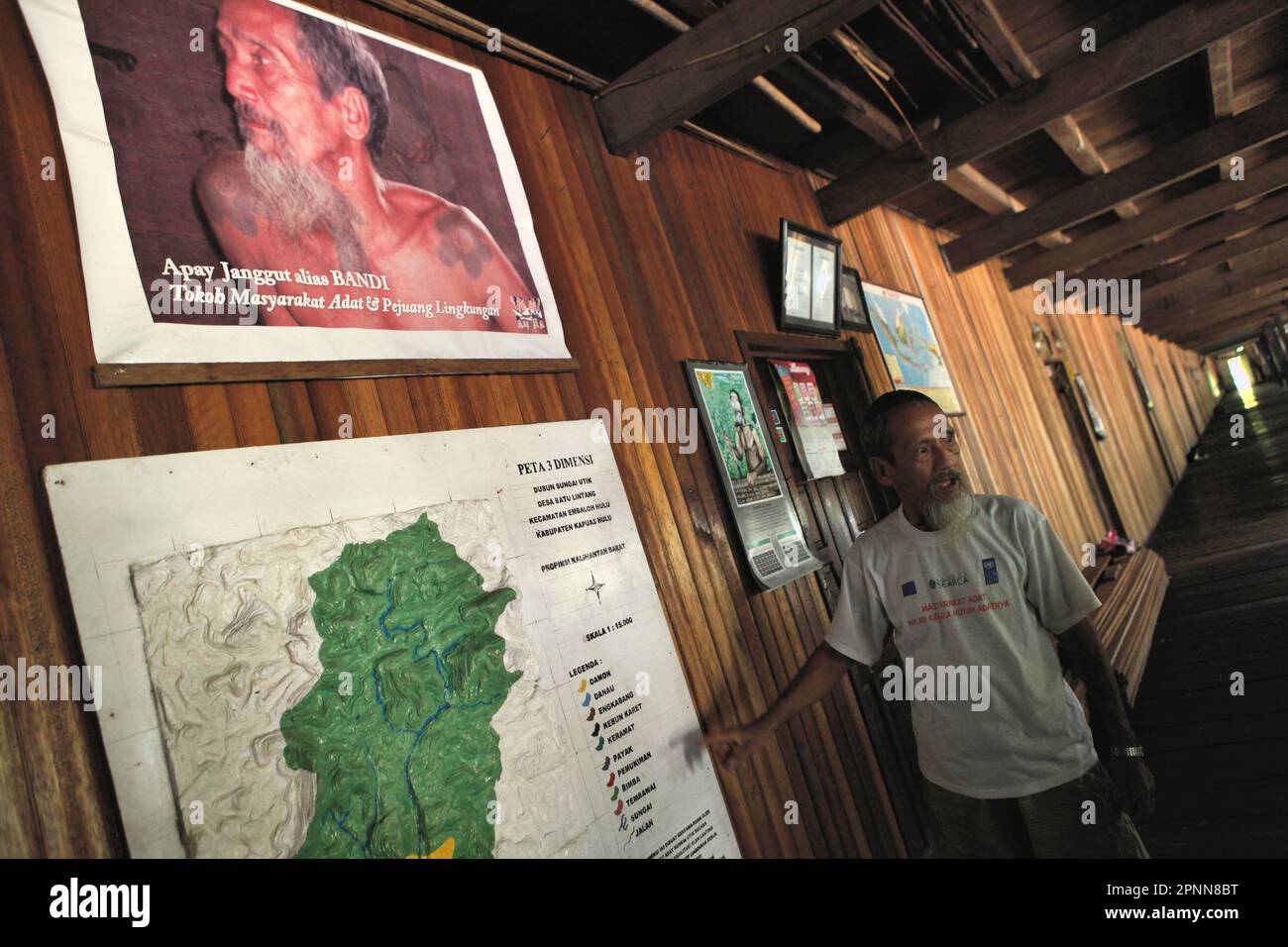 Bandi, conosciuto popolarmente come Apay Janggut, un difensore ambientale e anziano della comunità tradizionale della comunità IBAN di Dayak, dà spiegazioni mentre sta in piedi di fronte alla mappa della foresta consueta che la sua comunità sta gestendo, alla loro longhouse a Sungai Utik, Kapuas Hulu, Kalimantan occidentale, Indonesia. La conoscenza indigena può essere una fonte unica di tecniche per l'adattamento al cambiamento climatico e può essere favorita rispetto alla conoscenza generata esternamente, secondo il rapporto del 2023 pubblicato dal Gruppo intergovernativo sui cambiamenti climatici (IPCC). Foto Stock