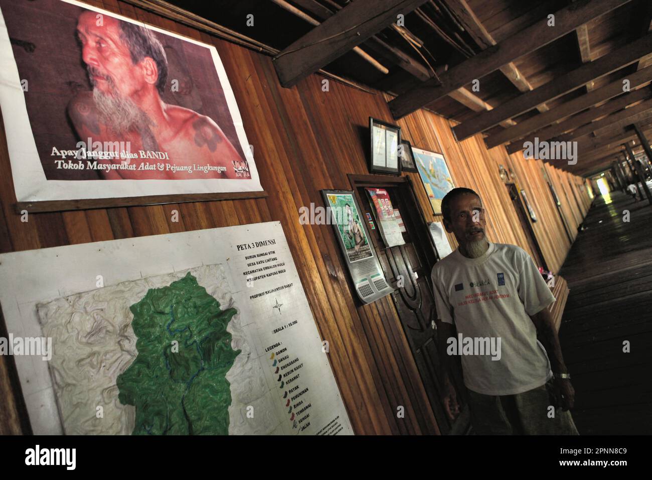 Bandi, conosciuto popolarmente come Apay Janggut, un difensore ambientale e anziano della comunità tradizionale della comunità IBAN di Dayak, dà spiegazioni mentre sta in piedi di fronte alla mappa della foresta consueta che la sua comunità sta gestendo, alla loro longhouse a Sungai Utik, Kapuas Hulu, Kalimantan occidentale, Indonesia. La conoscenza indigena può essere una fonte unica di tecniche per l'adattamento al cambiamento climatico e può essere favorita rispetto alla conoscenza generata esternamente, secondo il rapporto del 2023 pubblicato dal Gruppo intergovernativo sui cambiamenti climatici (IPCC). Foto Stock