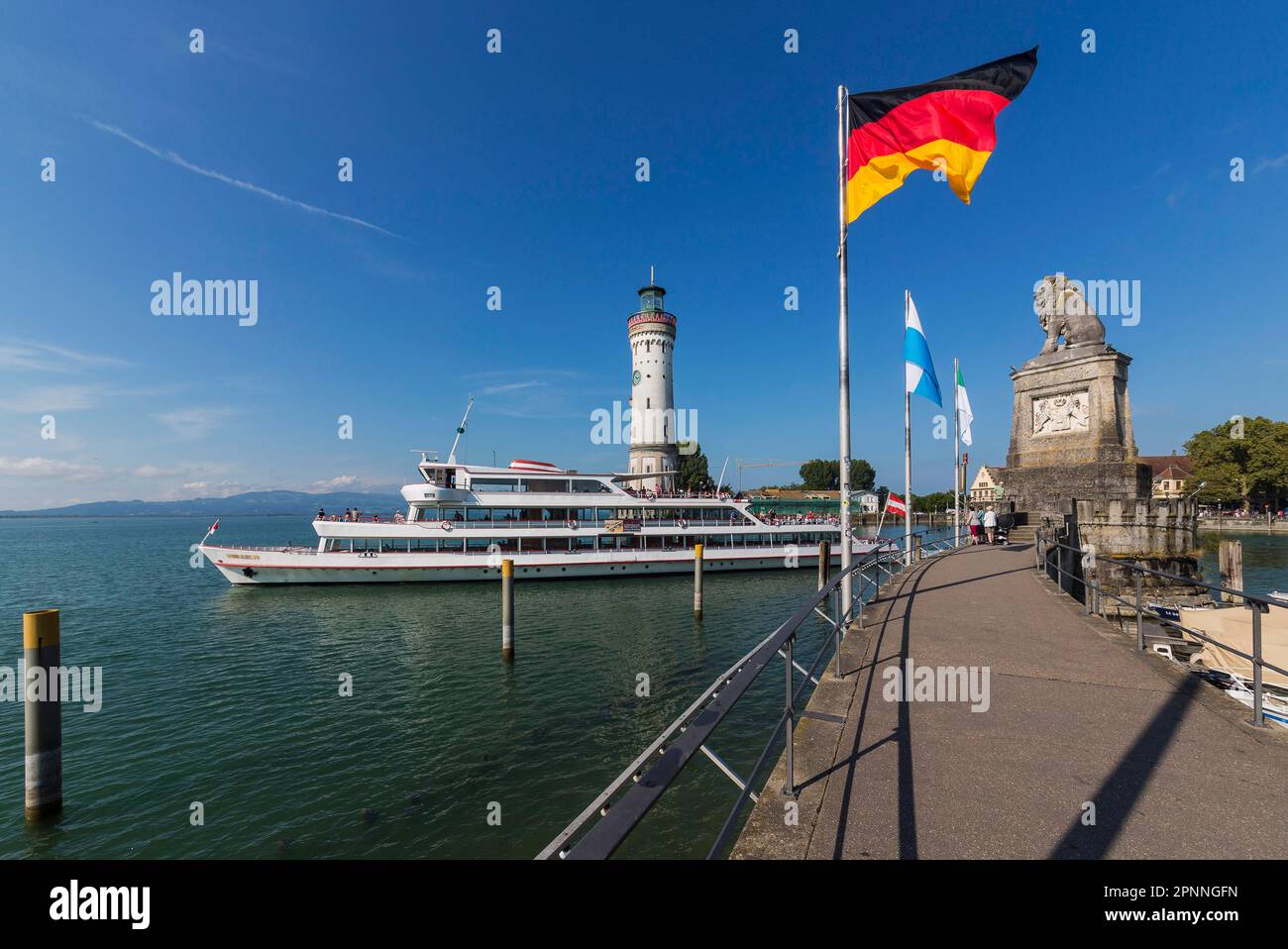 Ingresso al porto con faro e leone bavarese, bandiera tedesca, lago di Costanza, Lindau, Baviera, Germania Foto Stock
