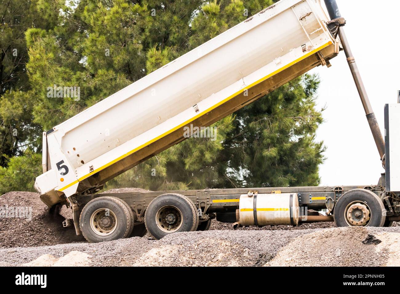 Fine del camion ribaltabile o del veicolo in prossimità di un cantiere edile in Sud Africa che cade da un carico di pietre Foto Stock