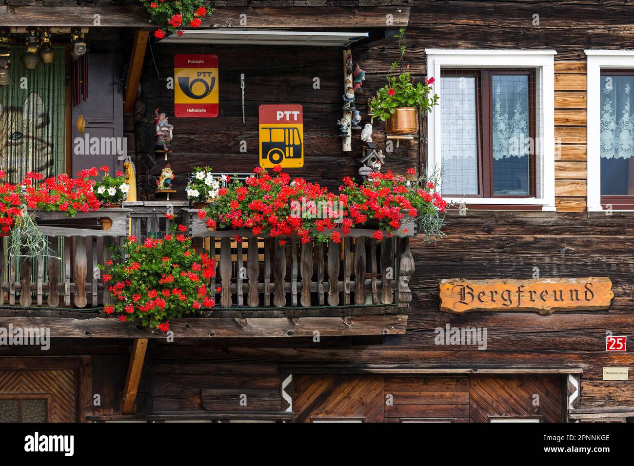 Tipica casa colonica vallesana in costruzione in legno, Haus Bergfreund con balcone e gerani, Niederwald, Goms, Vallese, Svizzera Foto Stock