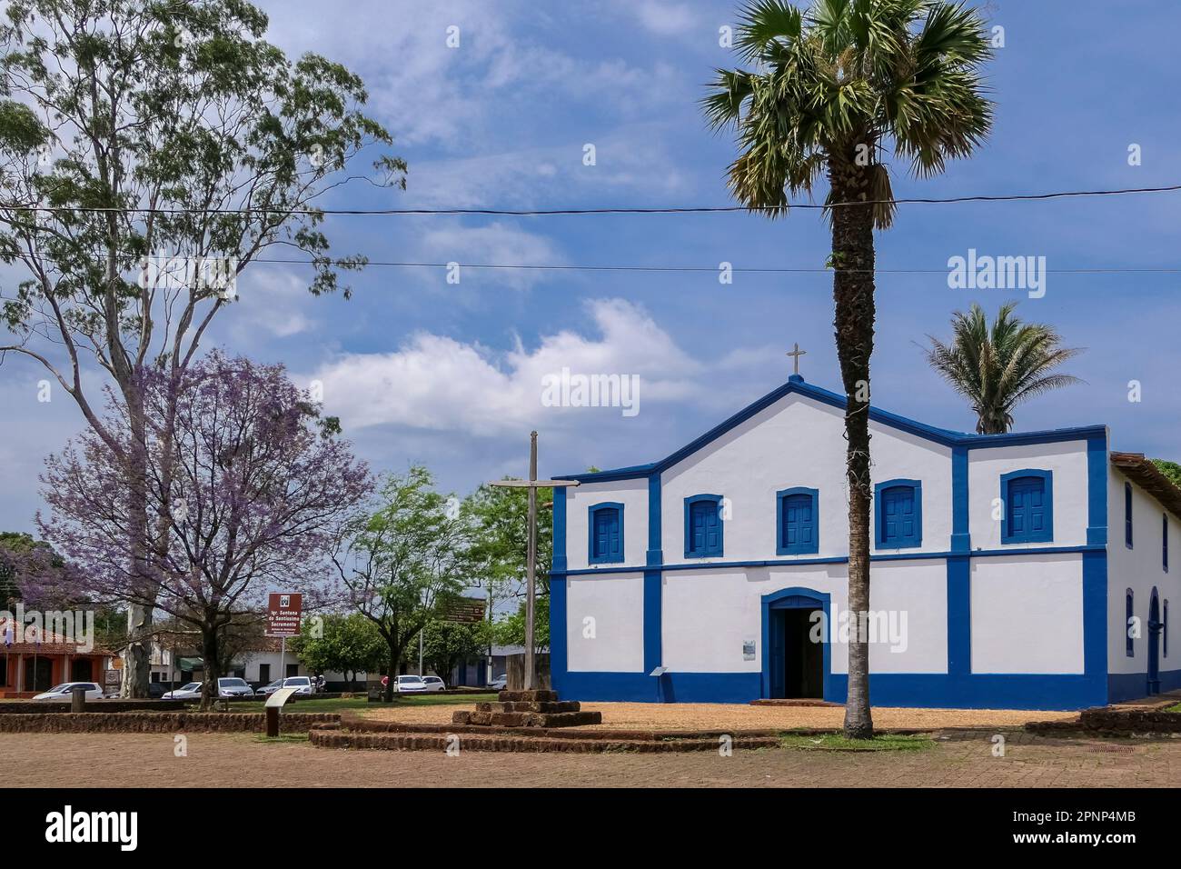 Chiesa storica Santana do Santissimo con albero fiorito e palme, Chapada dos Guimarães, Mato Grosso, Brasile Foto Stock