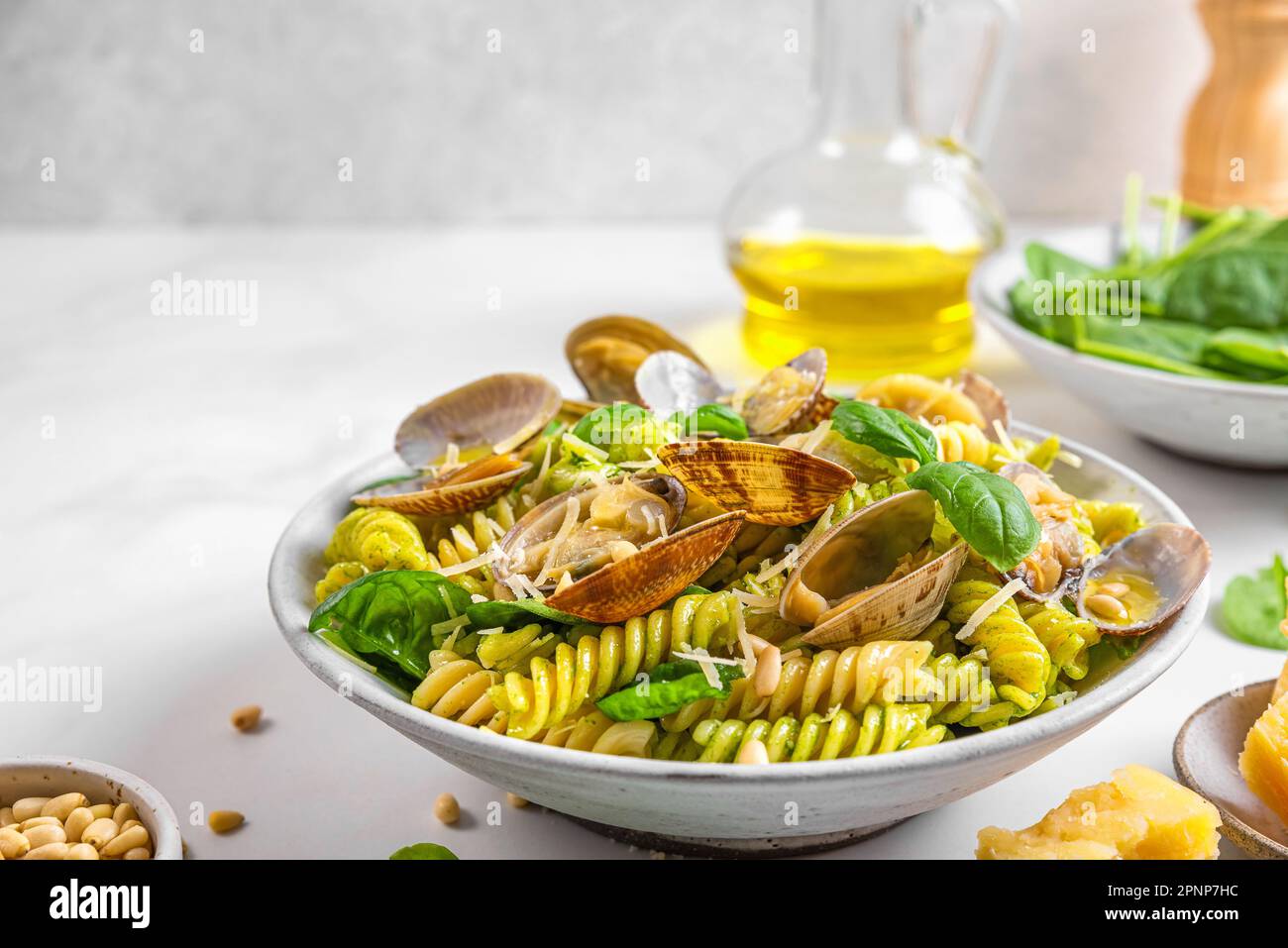 Cucina italiana. Pasta di pesce con vongole di vongole di vongole, parmigiano, spinaci, pinoli e olio d'oliva. Dieta mediterranea Foto Stock
