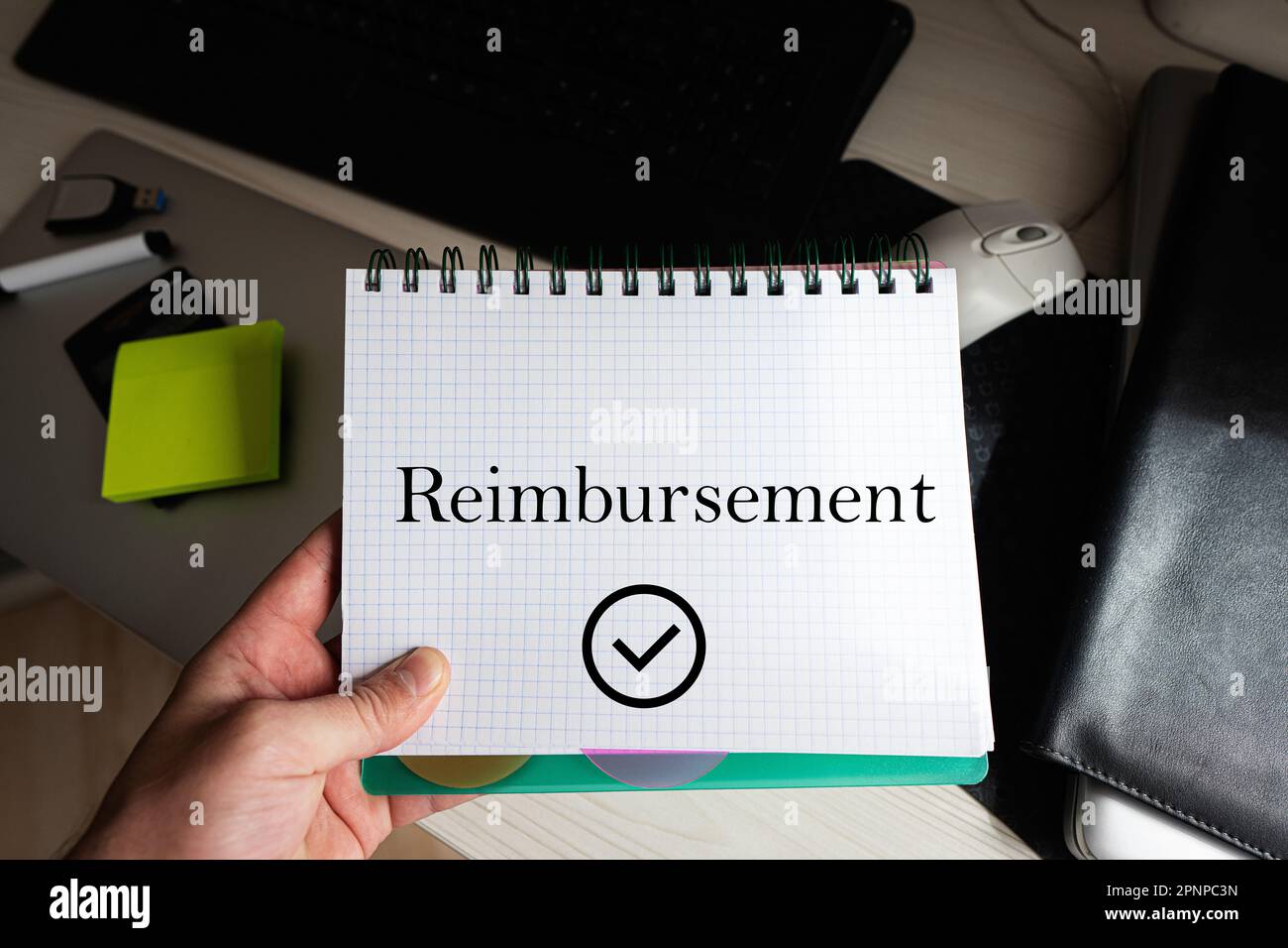 Parola di rimborso sul notebook che tiene l'uomo contro il desktop. Foto Stock