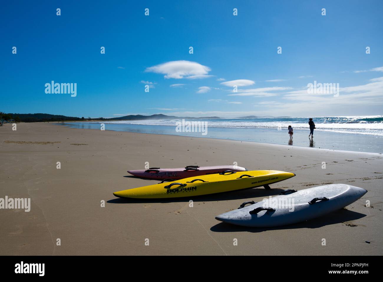 Lifesaver paddle boards / sci da surf giacendo fianco a fianco su una spiaggia in estate contro un cielo blu Foto Stock