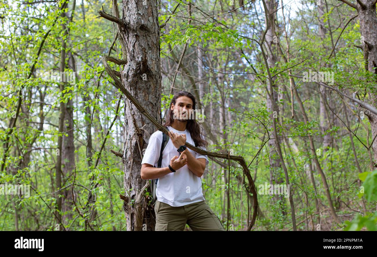 Uomo lungo capelli che cammina nella foresta Foto Stock