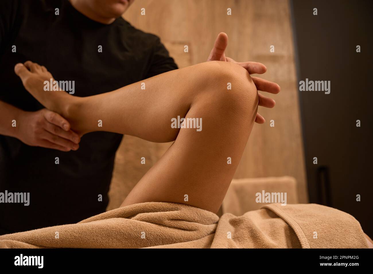 Foto ravvicinata, l'osteopata dell'uomo sta controllando i riflessi nella gamba di una donna Foto Stock
