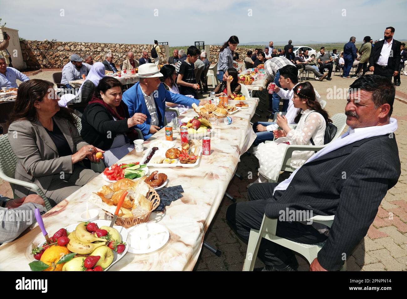 Le famiglie Yazidi mangiano i vari piatti che hanno preparato nelle loro case e li hanno lasciati sui tavoli comuni per gli ospiti durante la celebrazione del mercoledì Rosso Vacanza nel villaggio di Bacinê. I curdi Yazidi che vivono nel villaggio di Bacine del distretto di Midyat e i distretti di Besiri in Turchia hanno celebrato la festa del mercoledì rosso, conosciuta come 'Charshema Sor' in curdo, con gioia con vari intrattenimenti. Uomini, donne e bambini di 10 famiglie Yazidi che vivono nel villaggio di Bacine si sono riuniti al Centro Culturale Yazidi dopo le preghiere del mattino, indossando gli abiti più colorati e belli. Yazidis crede che aprile sia un h Foto Stock