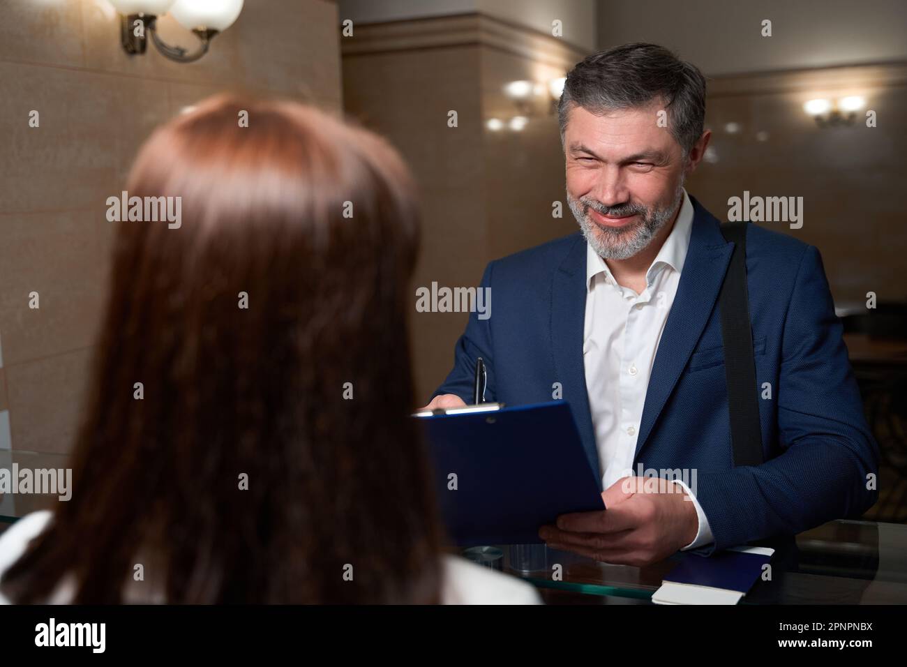 Il cliente è venuto in hotel e firma il documento Foto Stock