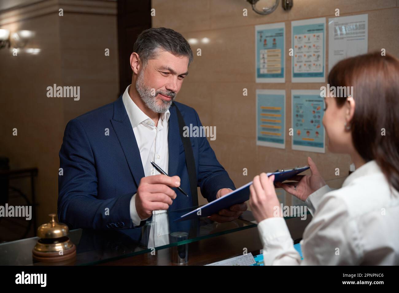 Un uomo d'affari è venuto in albergo e firma il documento Foto Stock