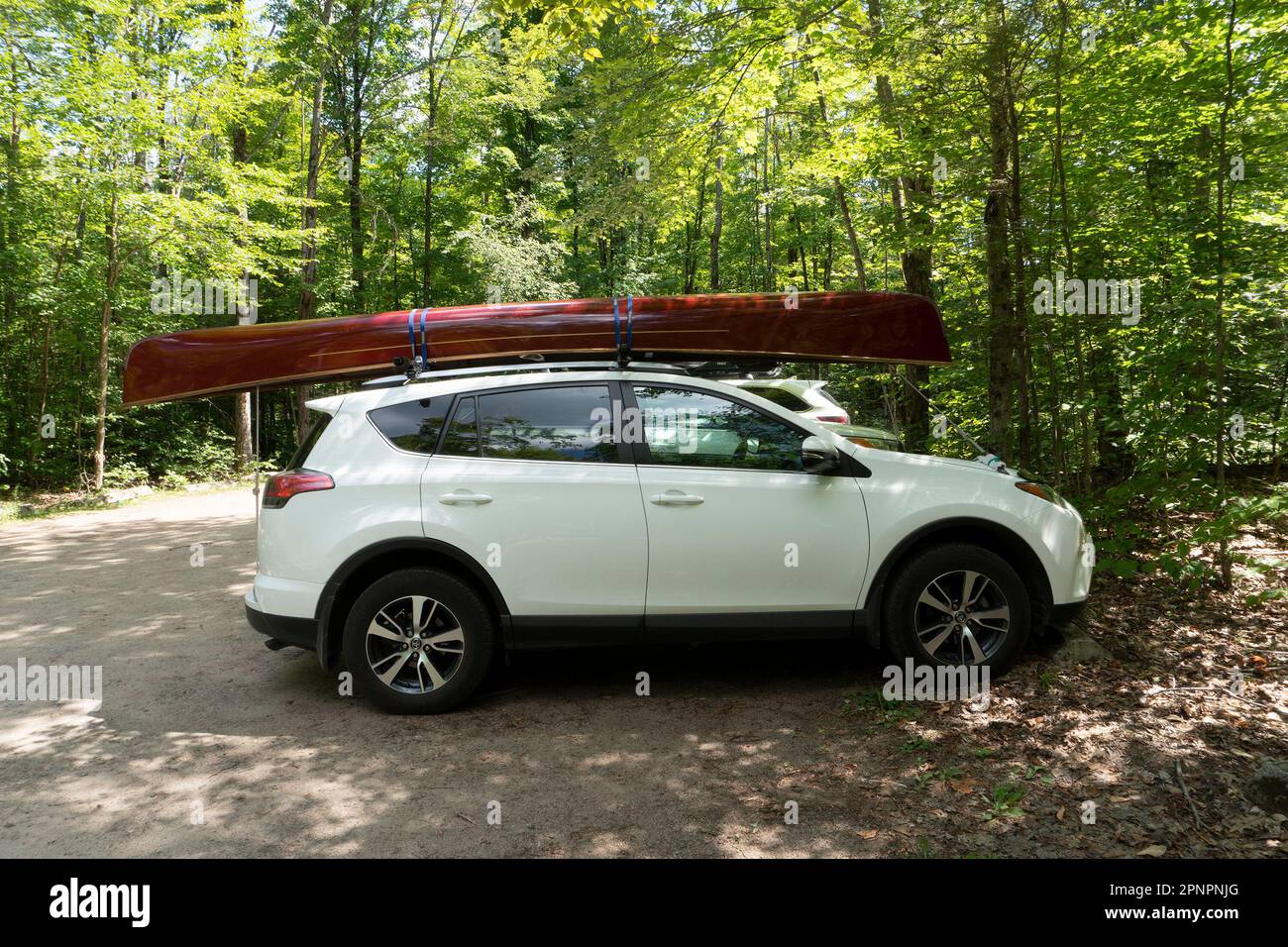 Kayak marrone lucido, bello, legato al portapacchi di un'auto bianca Foto Stock