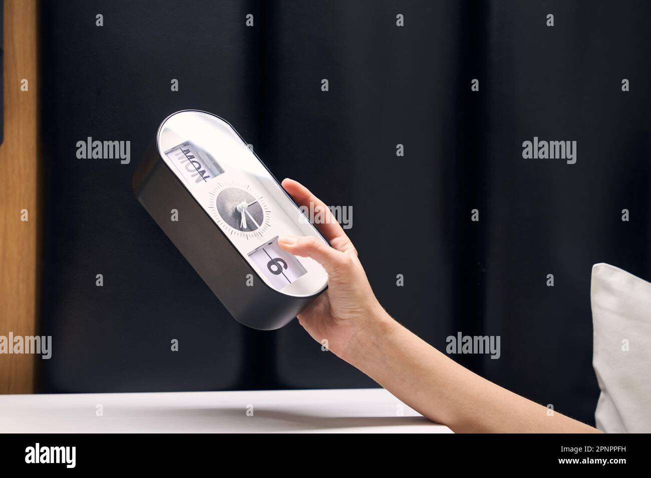 La donna tiene in mano una sveglia elettronica Foto Stock