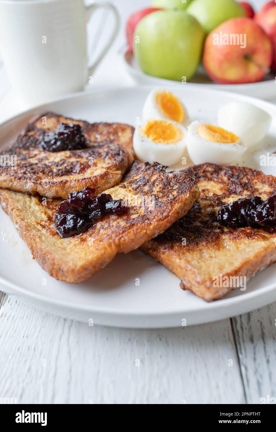 Toast alla francese con marmellata di mirtilli e uova sode su un piatto per la colazione Foto Stock