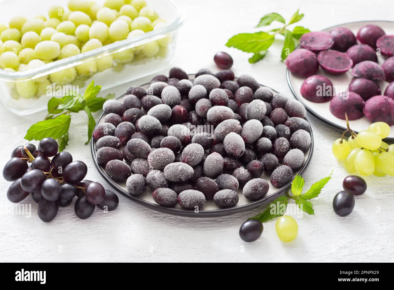 Metodi di congelamento delle uve: Surgelate, congelate con zucchero e puree congelate su fondo grigio chiaro. Preparazioni sane fatte in casa Foto Stock
