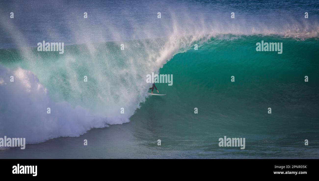 Surfista surfing una gigantesca onda barile, Barrack Point, Shellhave, New South Wales, Australia Foto Stock