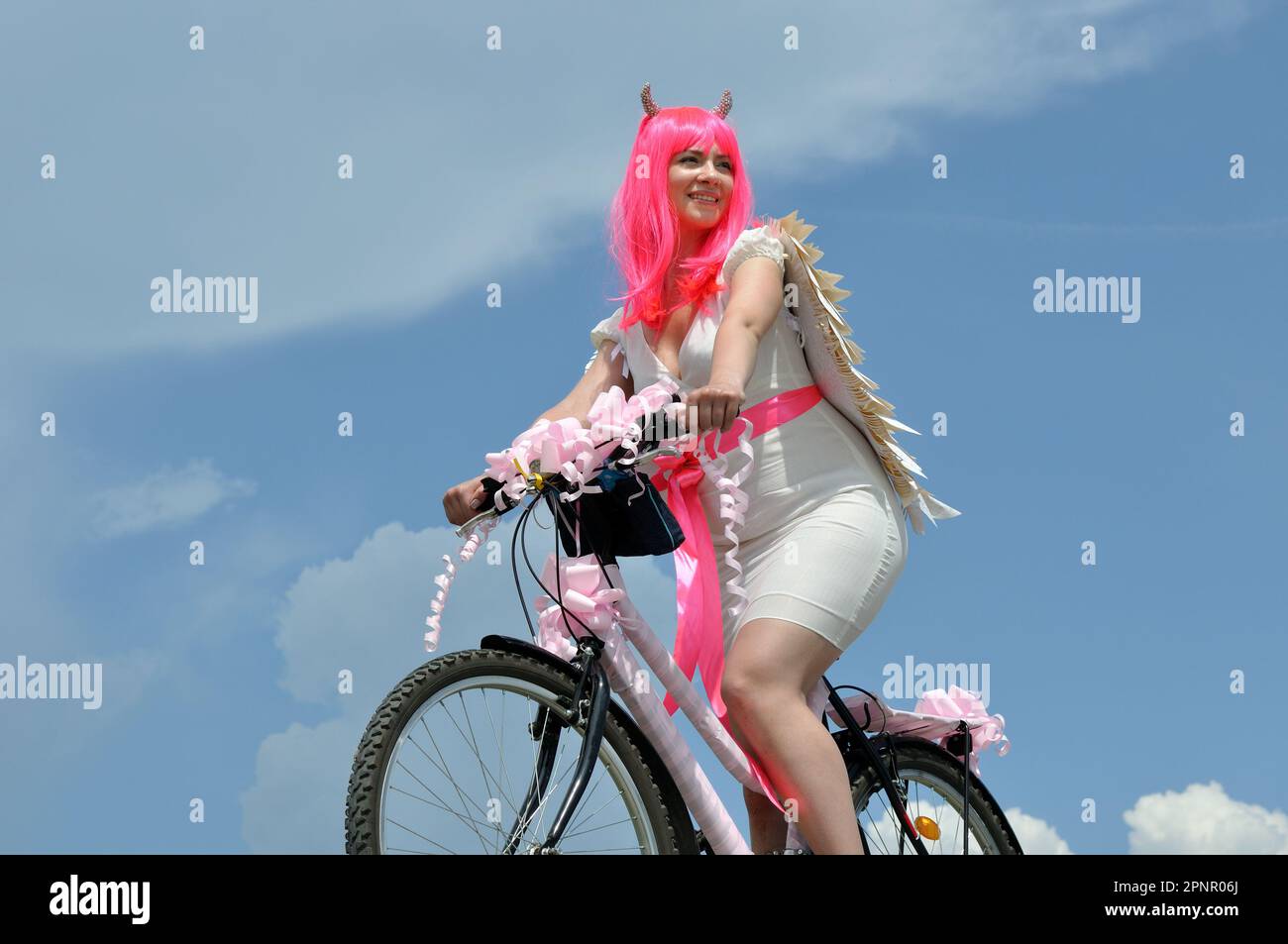 donna attraente con moto in costume demone in viaggio durante il giorno d'estate Foto Stock