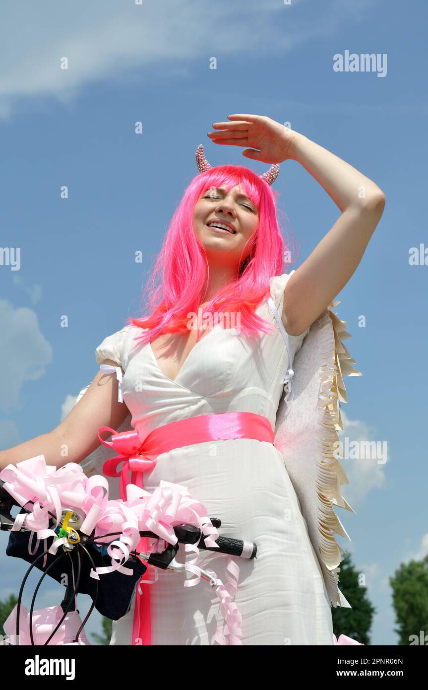 donna attraente con moto in costume demone in viaggio nei giorni estivi, composizione verticale Foto Stock