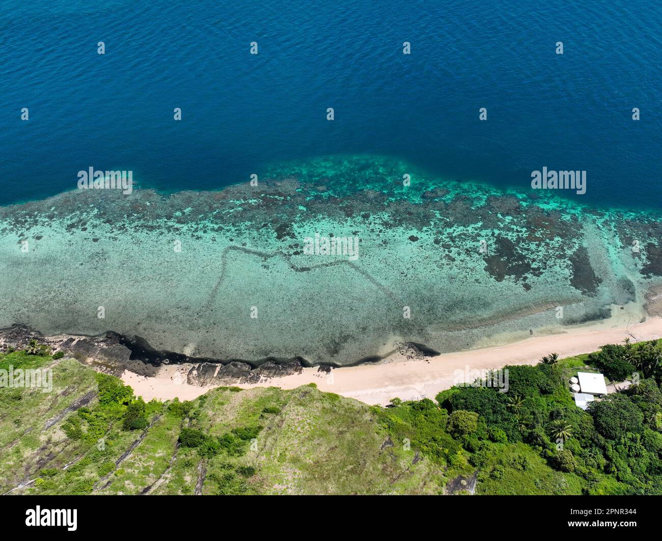 Veduta aerea verso il basso della spiaggia e dell'acqua blu tropicale nello stretto di Torres, Foto Stock