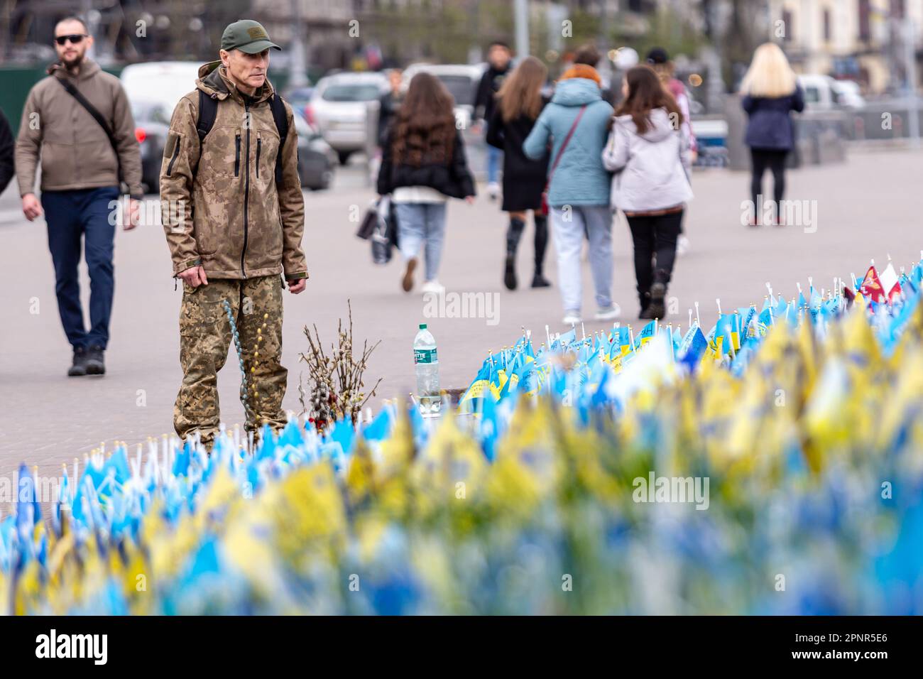 Kiev, Ucraina. 20th Apr, 2023. Un uomo si ferma con bandiere nazionali ucraine blu e gialle con i nomi dei soldati caduti su Maidan Nezalezhnosti (Piazza dell'Indipendenza) nel centro di Kyiv, la capitale dell'Ucraina il 20 aprile 2023. Le famiglie e gli amici del serviceman ucciso lasciano le bandiere come un memoriale per i loro cari. Mentre l'invasione su larga scala dell'Ucraina da parte delle forze russe continua paese si prepara per una contro-offensiva. (Foto di Dominika Zarzycka/Sipa USA) Credit: Sipa USA/Alamy Live News Foto Stock