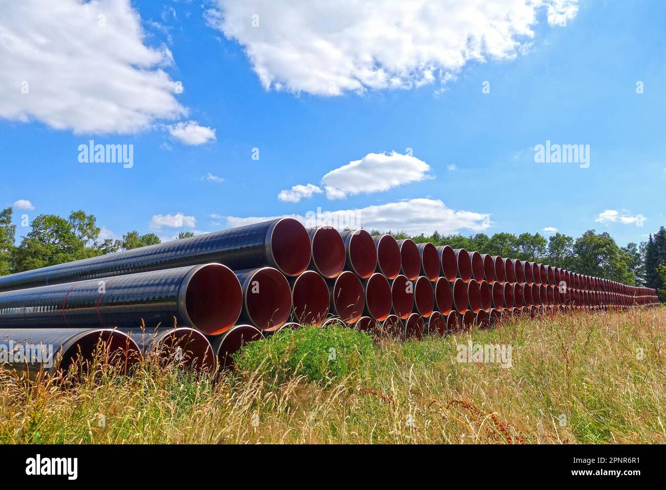 Pila di lunghi tubi di ferro per Costruzioni di pipeline Foto Stock