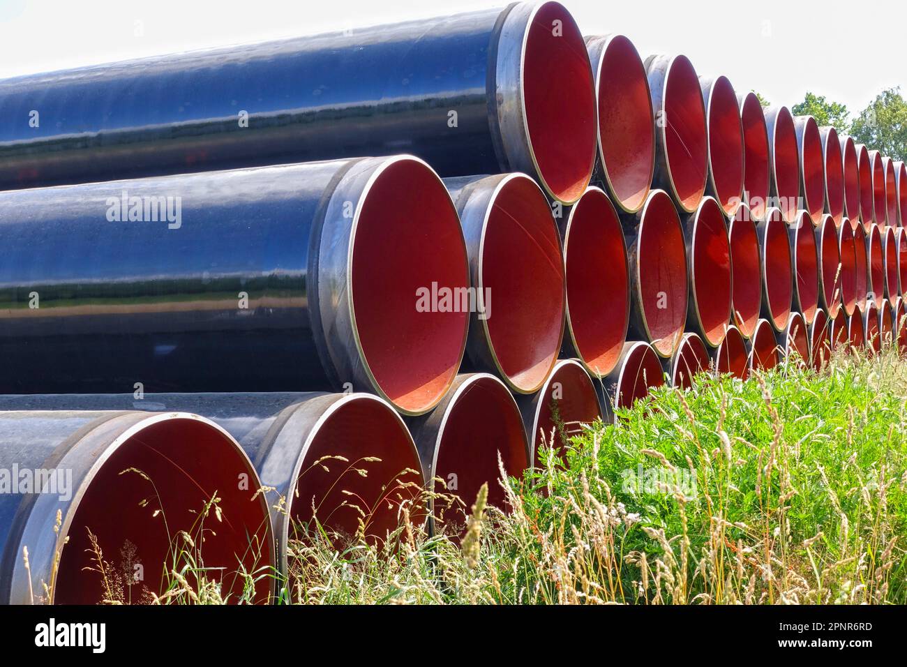 Pila di lunghi tubi di ferro per Costruzioni di pipeline Foto Stock
