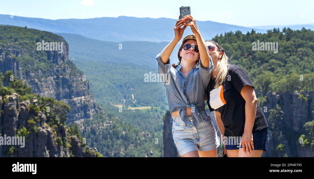 Il paesaggio del canyon di Tazi a Manavgat Turchia. Le ragazze felici prendono selfie sul pendio ripido. valle e scogliera Foto Stock