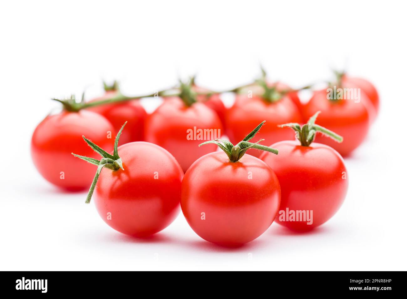 Piccoli pomodori ciliegini rossi su sfondo bianco. Foto Stock