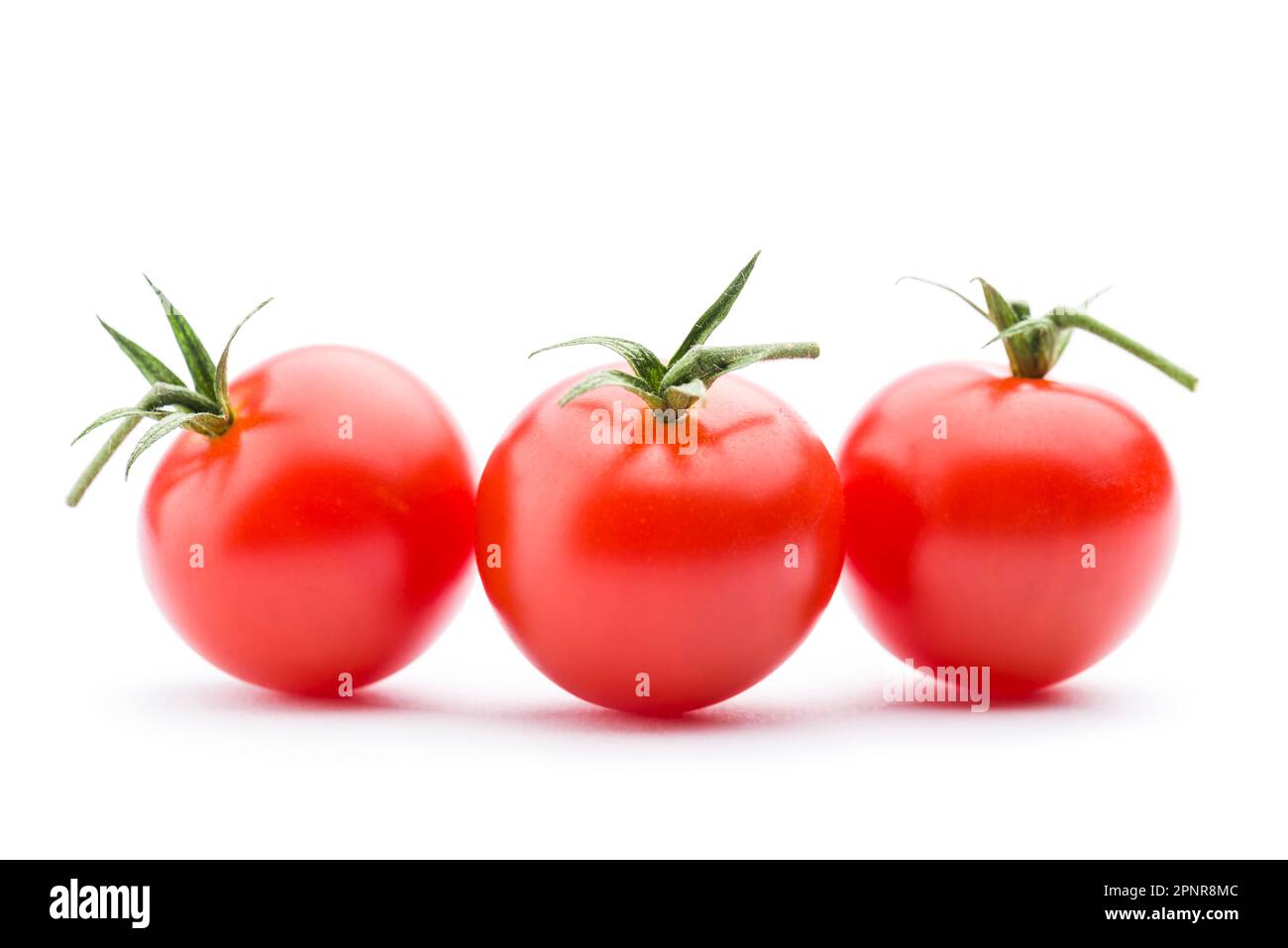 Piccoli pomodori ciliegini rossi su sfondo bianco. Foto Stock