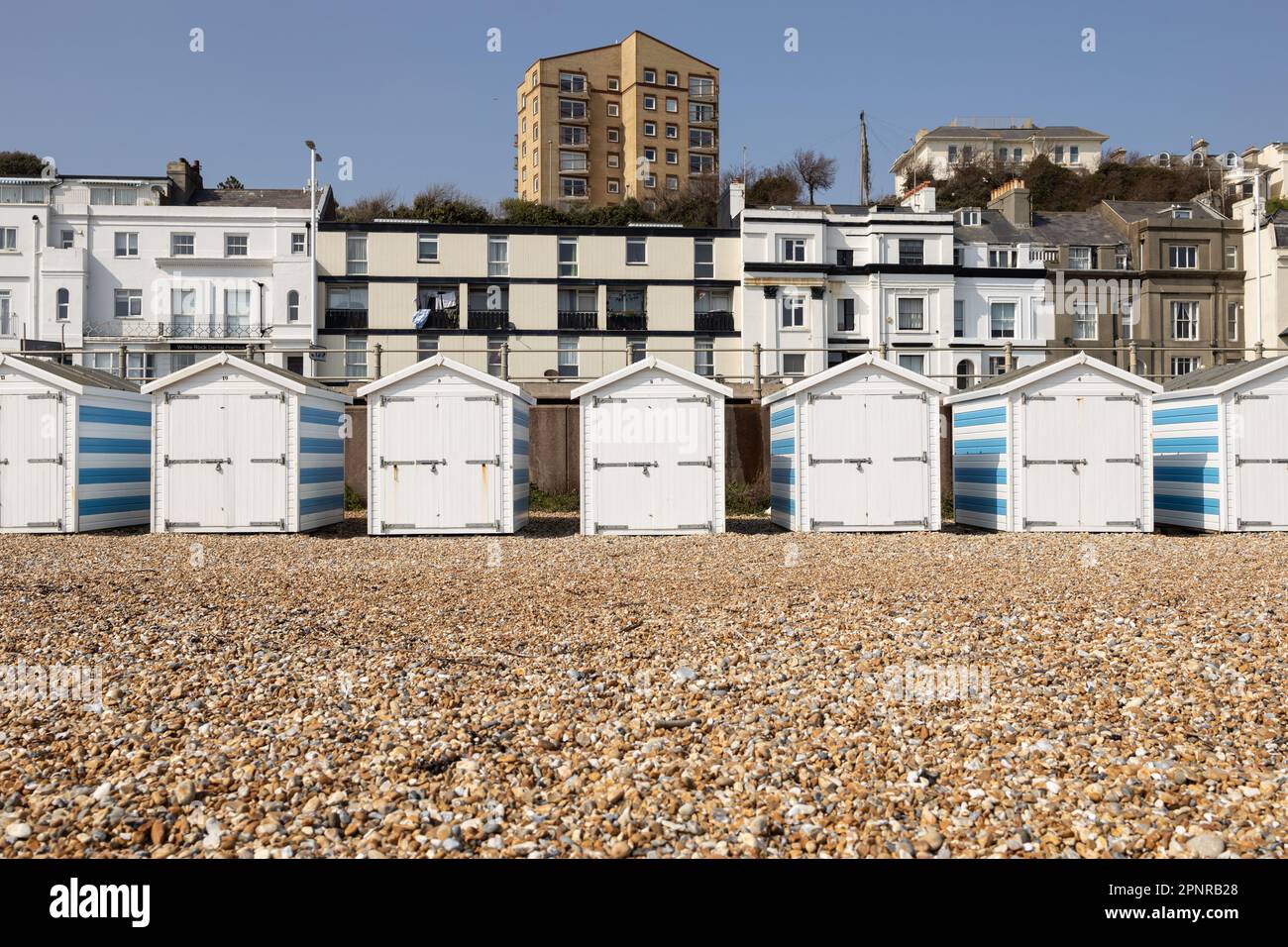 Capanne sulla spiaggia con edifici dietro Foto Stock