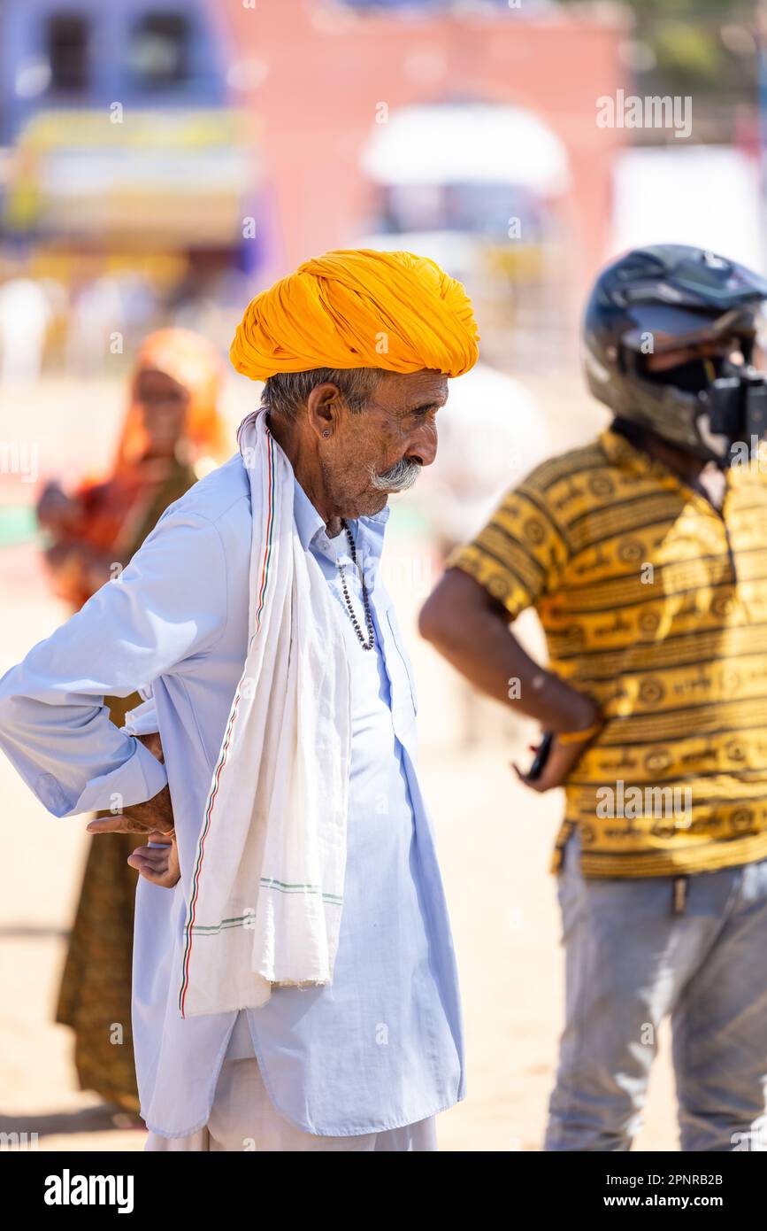 Pushkar, India - ottobre 2022: Fiera di Pushkar, Ritratto di un vecchio maschio rajasthani con abiti tradizionali bianchi e turbano colorato al terreno fieristico di pushkar Foto Stock