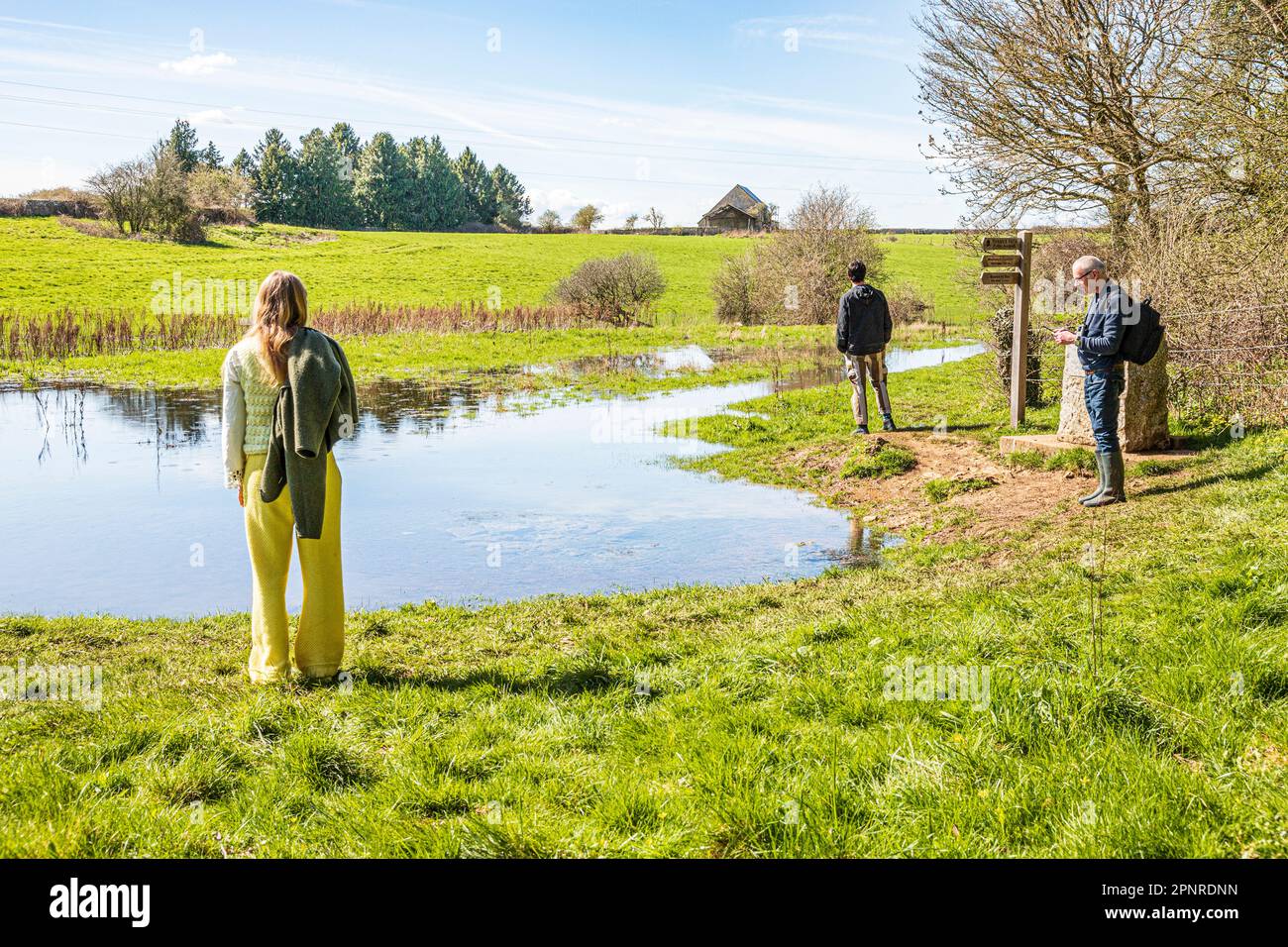 Persone all'inizio del Thames Path alla fonte del Tamigi a Tamigi testa sul Cotswolds vicino a Kemble, Gloucestershire UK. Foto Stock