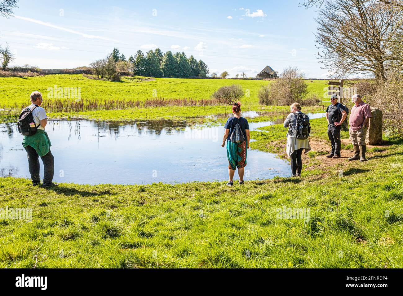 Persone all'inizio del Thames Path alla fonte del Tamigi a Tamigi testa sul Cotswolds vicino a Kemble, Gloucestershire UK. Foto Stock